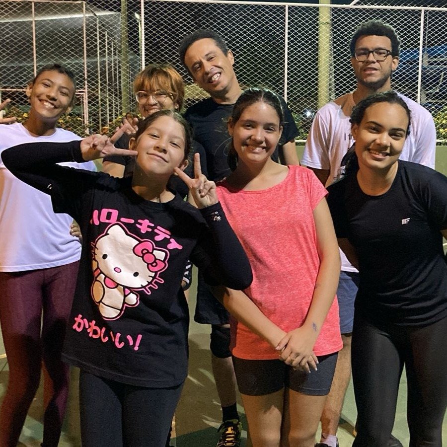 Alunos de vôlei fazendo pose para a foto após praticar a atividade
