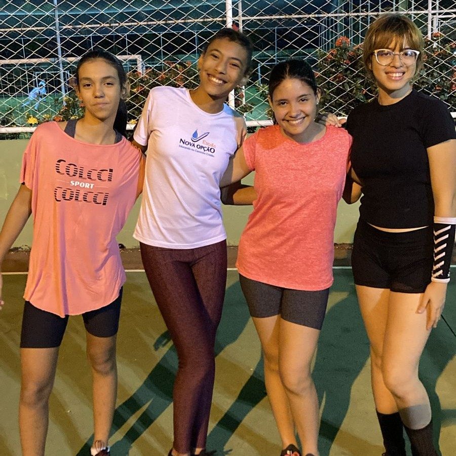 Alunas de vôlei fazendo pose para a foto após praticar a atividade